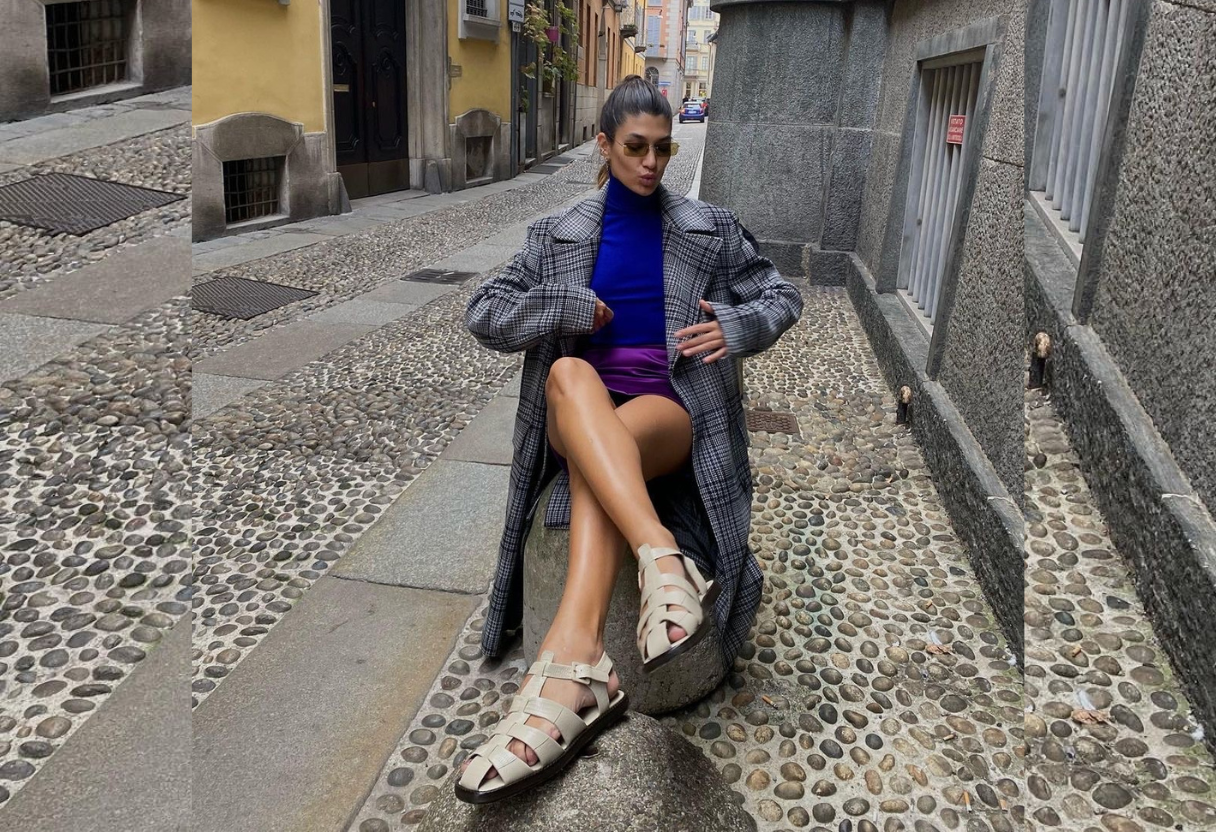 a woman is sitting on a rock in the middle of a street